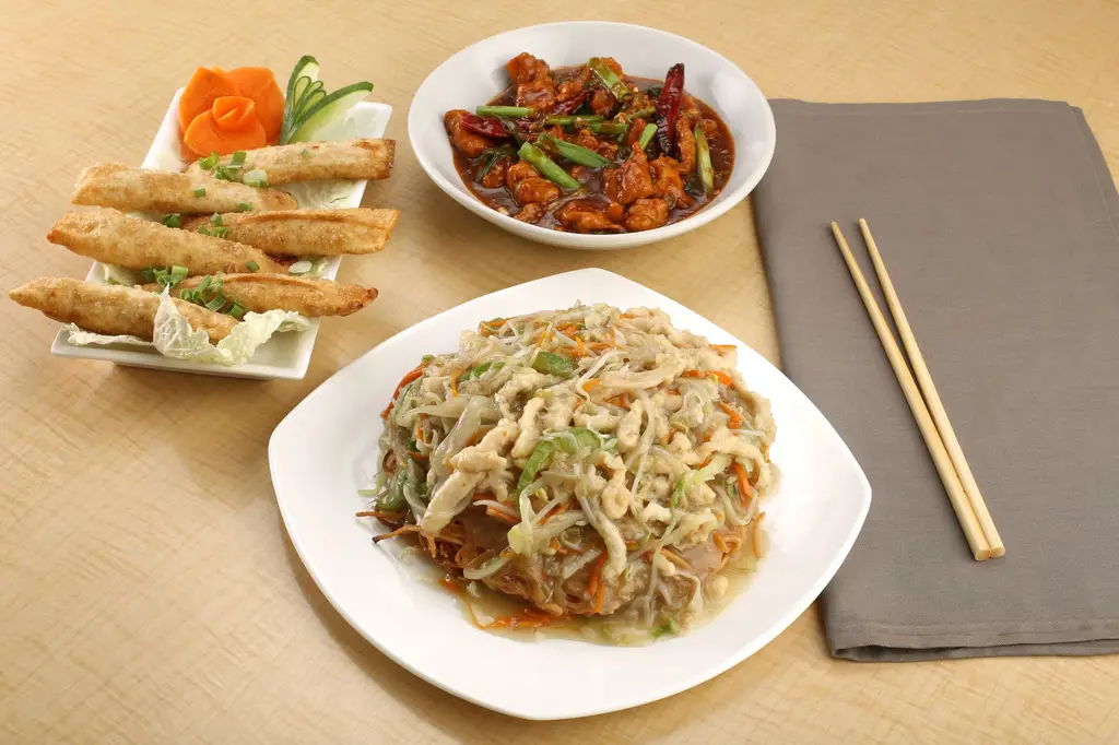 Delicious Asian meal featuring noodles, stir fry, and spring rolls, perfect for an indulgent dinner.