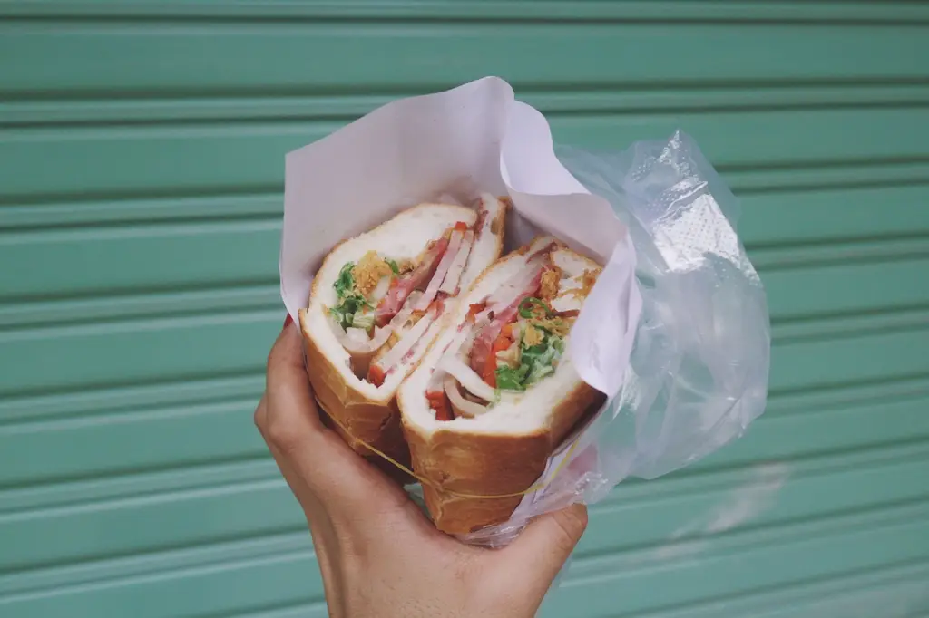 Close-up of a hand holding a fresh sandwich in Ho Chi Minh City, Vietnam.