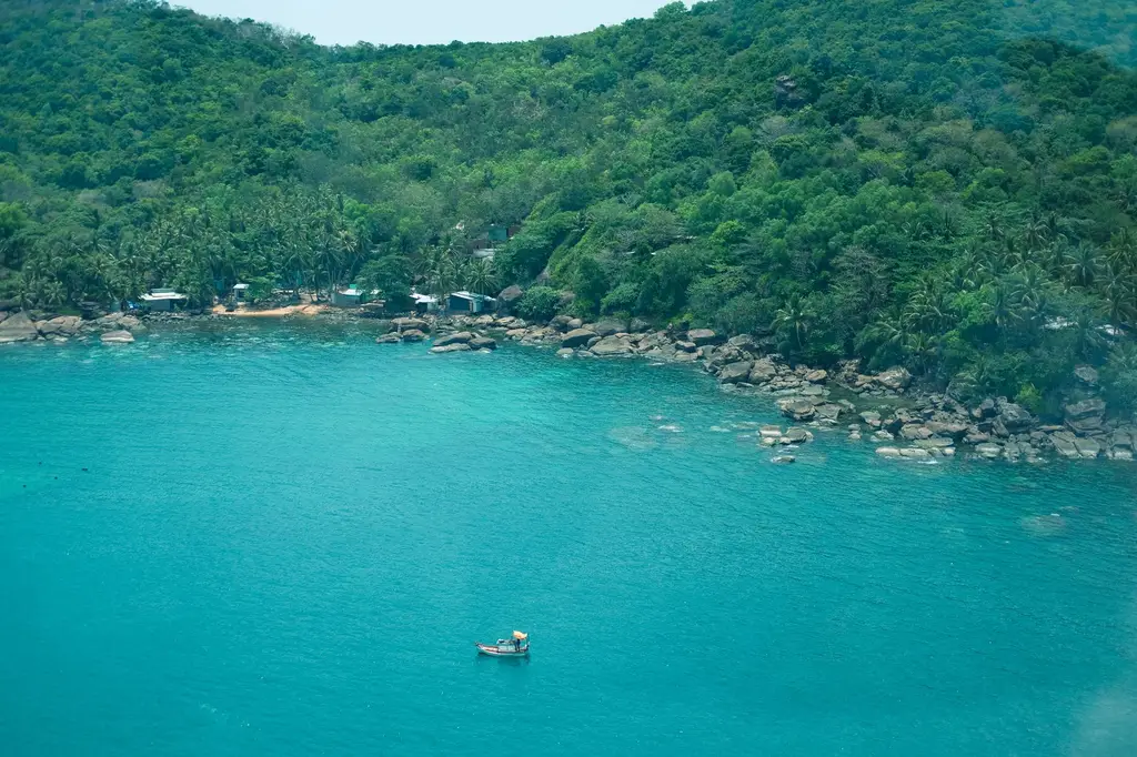 A picturesque aerial view of Phu Quoc island's tropical coastline with lush green forests and clear blue ocean.